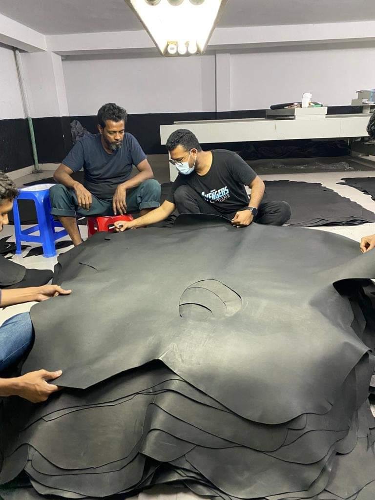 Artisans Inspecting and Cutting Large Leather Hide - PoshPatternBD